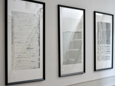 Three abstract art prints in black frames on a white wall at Ty Carmel in Rhosneigr