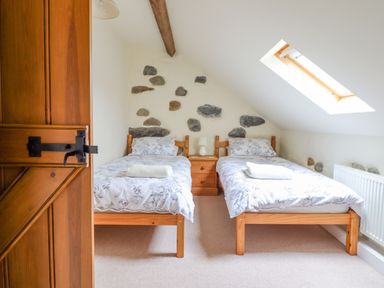 A bedroom with two single beds and a skylight window at Ysgybor Yd in Chwilog near Criccieth