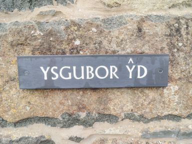 A sign with the text Ysgubor Yd on a stone wall at Ysgubor Yd in Chwilog near Criccieth