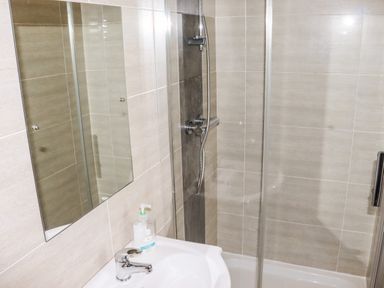 A bathroom with a sink a mirror and a shower at Yr Hen Festri in Y Felinheli
