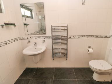 A bathroom with a sink toilet towel warmer and mirror at Bluebell Lodge in Saltburn-by-the-Sea