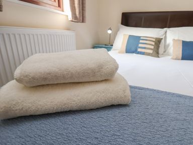 A bedroom with towels on a bed at Bluebell Lodge in Saltburn-by-the-Sea