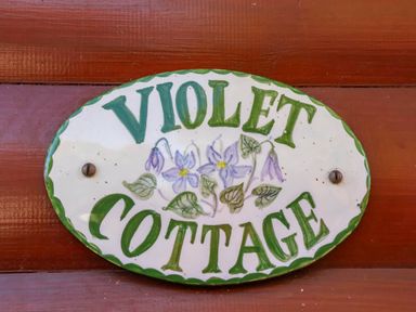 A sign reading Violet Cottage with floral design at Violet Lodge in Saltburn-by-the-Sea