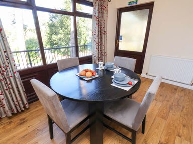 A dining room with a round table and chairs at Violet Lodge in Saltburn-by-the-Sea