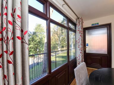 A dining room with large windows overlooking a balcony at Violet Lodge Saltburn-by-the-Sea