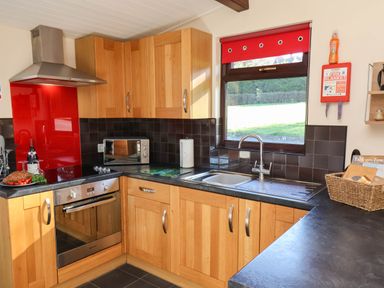 A kitchen with an oven, sink, and microwave at Violet Lodge Saltburn-by-the-Sea