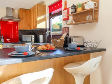 A kitchen with counter, utensils, croissants, and a window at Violet Lodge Saltburn-by-the-Sea