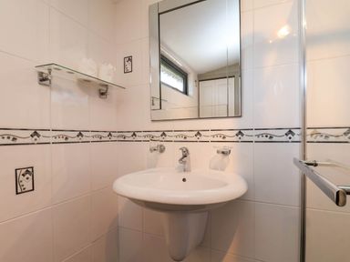 A bathroom with a sink and mirror at Violet Lodge Saltburn-by-the-Sea