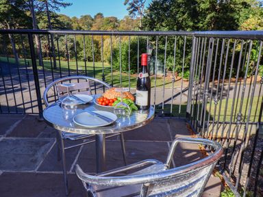 A table set with wine and food on a balcony at Violet Lodge in Saltburn-by-the-Sea