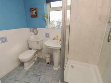 A bathroom with a toilet sink and shower cubicle at Bangor Cottage in Bangor