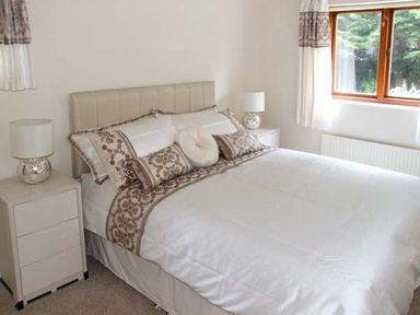 A bedroom with a double bed two bedside tables with lamps and a window with curtains at 9 Bancroft Place in Stratford-upon-Avon