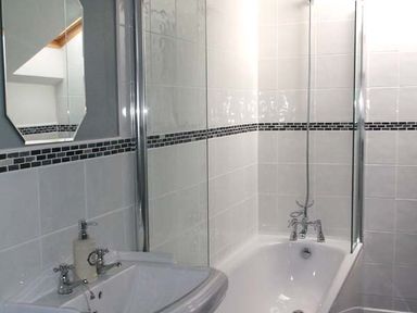A bathroom with a sink and a bathtub with a shower at Woodstone Barn in Whitchurch near Tavistock