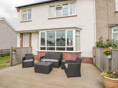 Outdoor patio with wicker furniture and potted plants at Dune View in Beadnell