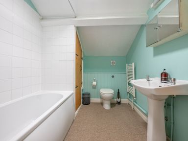 A bathroom with a bathtub toilet and sink at The Coach House in Gilwern near Crickhowell and Abergavenny