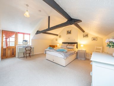 A bedroom with a bed bedside tables a dressing table and a chair at The Coach House in Gilwern near Crickhowell and Abergavenny