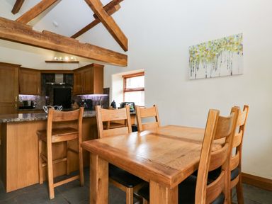 A kitchen with wooden furniture at Yew Tree Cottage in Torver