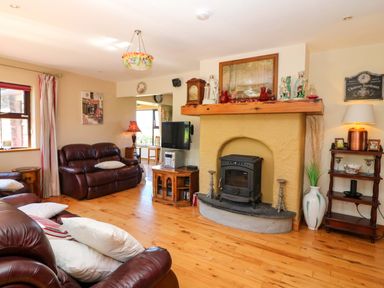 A living room with a fireplace and sofa at Stone Cottage in Waterville, County Kerry