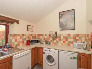A kitchen with dishwasher washing machine microwave and toaster at Hadrians View Banks near Brampton