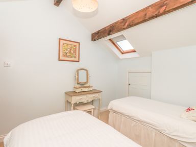 A bedroom with two single beds a dressing table with mirror under a skylight at Hadrians View Banks near Brampton