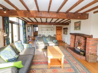 A living room with sofas coffee table fireplace and dining table at Hadrians View Banks near Brampton