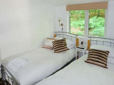 A bedroom with two beds and striped pillows at Top Lodge 4 Skiptory Howe White Cross Bay near Troutbeck Bridge