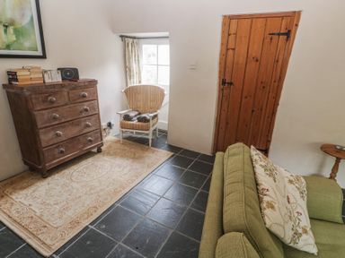 A living room with a chest of drawers, a rocking chair, and a sofa at Swallows St Keverne, Lizard Peninsula