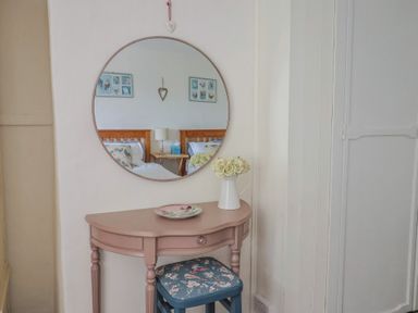 A bedroom corner with a table, chair, and mirror at Church Farmhouse in Winsham