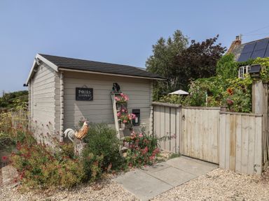 A parcel box and gate with flowers in the garden at Church Farmhouse in Winsham