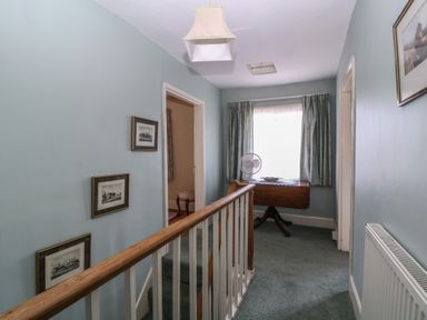A hallway with a railing and photographs at The Lock House in Gloucester