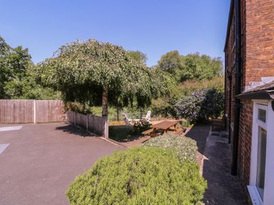 A garden with a tree, table, and chairs at The Lock House in Gloucester