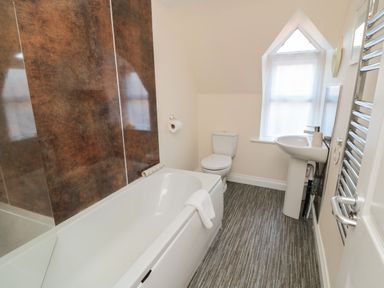 A bathroom with a bathtub sink toilet window and towel radiator at Carisbrooke House Apartment 6 in Scarborough