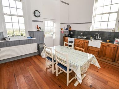 A kitchen with a wooden table and chairs a sink and appliances visible at The Old School House Gortermone near Carrigallen County Leitrim