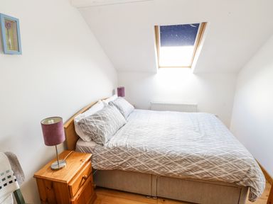 A bedroom with a double bed bedside tables lamps and a skylight window at The Old School House in Gortermone near Carrigallen County Leitrim