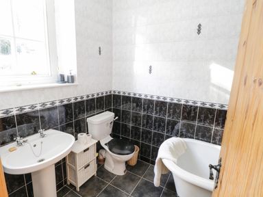 A bathroom with a pedestal sink toilet and bathtub at The Old School House in Gortermone near Carrigallen County Leitrim