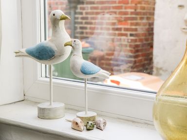 Two blue and white seagull figurines and three small mouse figurines on a windowsill at Inglenook Cottage in Whitby