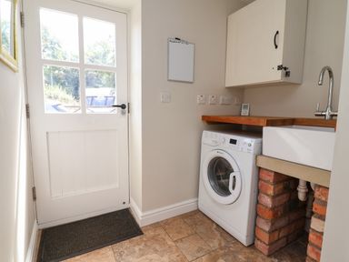 A utility room with a washing machine and sink at The Lambing Shed in Dyserth near Prestatyn