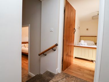 A staircase leading to a bedroom with a bed in The Lambing Shed Dyserth near Prestatyn