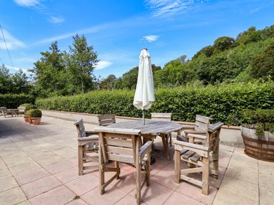 An outdoor seating area with a table and chairs at The Lambing Shed Dyserth near Prestatyn
