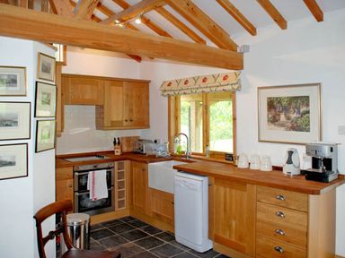 A kitchen with wooden cabinets a dishwasher and coffee machine at The Springs in Ashey near Brading and Ryde