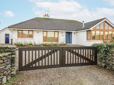A house with a wooden gate and gravel driveway at Lough Cluhir Cottage Union Hall, County Cork