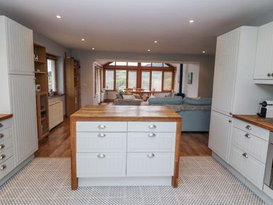 A kitchen with cabinets and an island at Lough Cluhir Cottage, Union Hall, County Cork