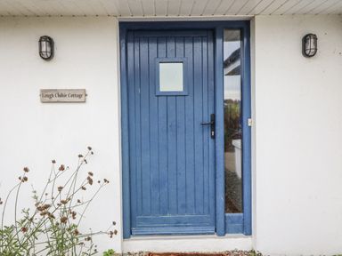 A blue door with a nameplate at Lough Cluhir Cottage in Union Hall, County Cork