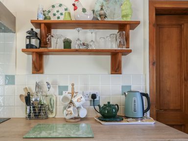 A kitchen with shelf and utensils at Lily Cottage Caeathro near Caernarfon