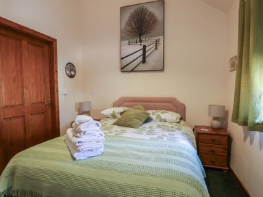 A bedroom with a bed and towels on it at Lily Cottage in Caeathro near Caernarfon