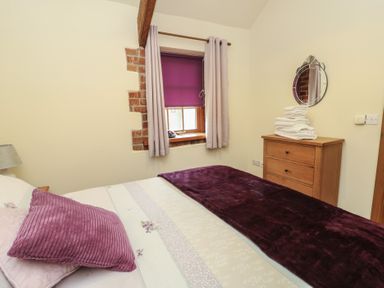 A bedroom with a bed and window at Lavender Cottage in Caeathro near Caernarfon