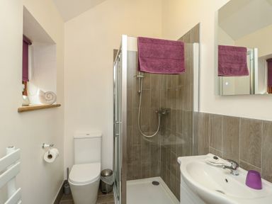 A bathroom with a shower and sink at Lavender Cottage in Caeathro near Caernarfon