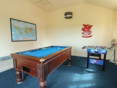 A game room with a pool table and foosball table at Bluebell Cottage Caeathro near Caernarfon