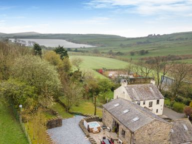 A rural property with stone and white houses near fields and a lake at Hill Side Barn Pennington near Ulverston