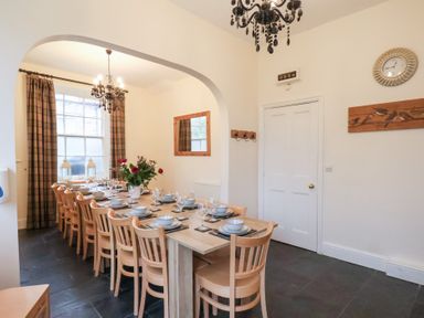 A dining room with a large table set for a meal at The Lodge in Snainton near Scarborough