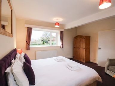 A bedroom with a bed and window at The Lodge in Snainton near Scarborough